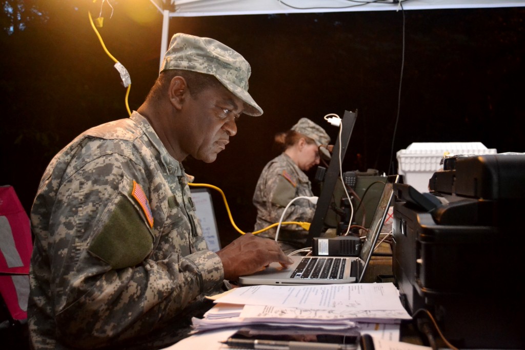 CLARK CREEK SOUTH CAMPGROUND, Acworth, June 5, 2015 – Maj. Herb Jones, the Operations Officer for 1st Brigade, Georgia State Defense Force (GSDF) and acting Incident Commander for Defender Northwest Georgia Field Training Exercise (FTX) 2015, scans over reports and prepares orders for the Soldiers. The FTX tests the capabilities of the Soldiers and staff of the GSDF in their ability to respond to a disaster. (Georgia State Defense Force photo by Master Sgt. Mark D. Woelzlein, Public Affairs Office)