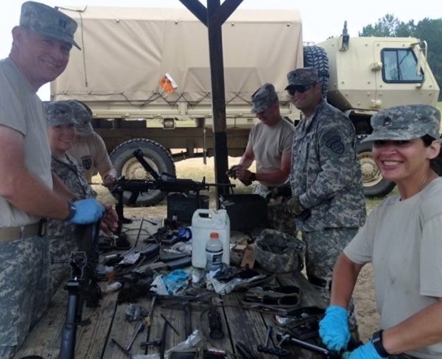 Georgia State Defense Force Soldiers field strip and clean M249 Machine Guns. Pictured left to right: CPT David Bignaught, SGT Christopher Lowry, WO1 Howard Seay, SPC Jon Van Holm, SSG Cindy Dunlap. Photo by PV2 Bernard Cameron