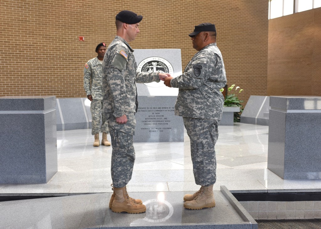 After receiving his first salute, 2nd Lt. Chapman, left, presents a silver dollar coin to Staff Sgt. Tello at the Georgia Public Safety Training Center in Forsyth, Georgia on August 14, 2016. (Georgia State Defense Force photo by Pfc. Davidson)